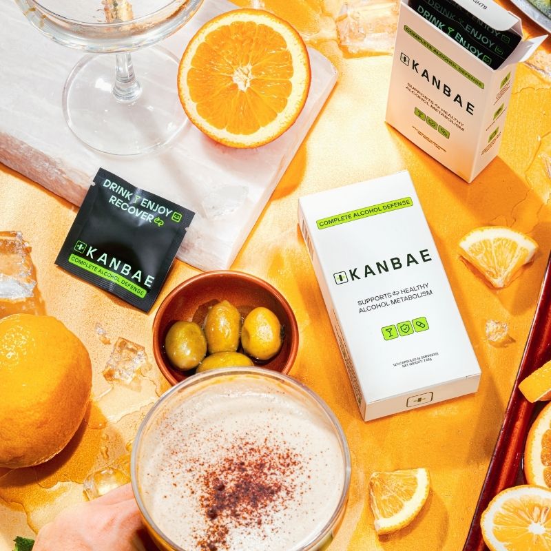 Lifestyle image of Kanbae Complete Alcohol Defence on a table with cocktails and other cocktail making ingredients.